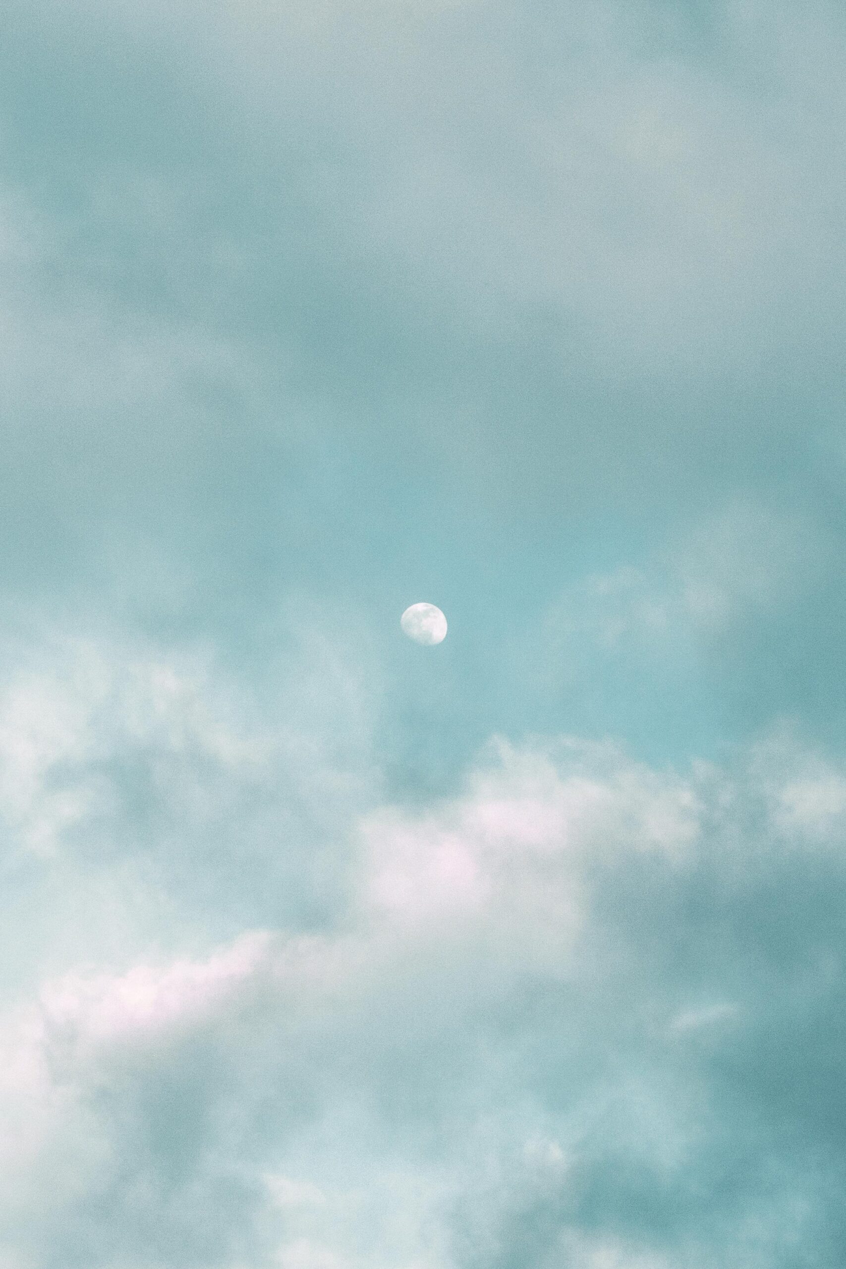 image of wispy clouds and sky with three-quarter moon peeking through